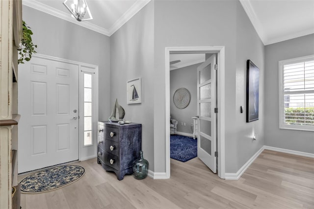 entryway featuring light wood-type flooring, a chandelier, and crown molding