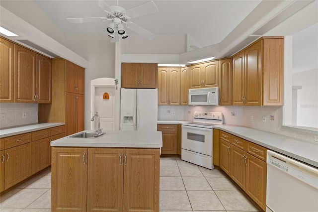 kitchen with sink, white appliances, an island with sink, and light tile patterned floors