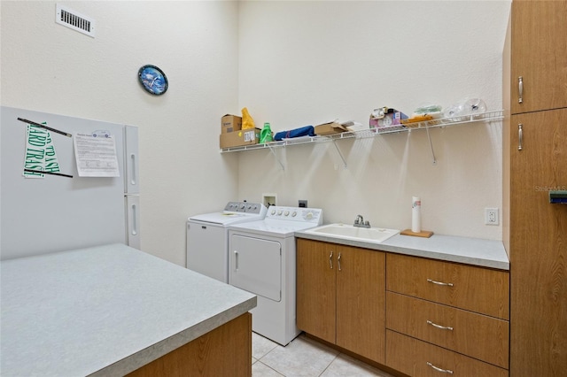 laundry room featuring cabinets, sink, washer and dryer, and light tile patterned floors