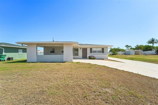 ranch-style home featuring a front lawn and a carport