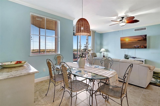 tiled dining room with ornamental molding and ceiling fan