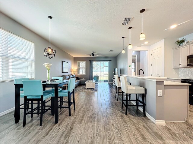 8858 Tuscany Isles Dr, Punta Gorda, FL 33950 - dining room with ceiling fan, a textured ceiling, and light wood-type flooring