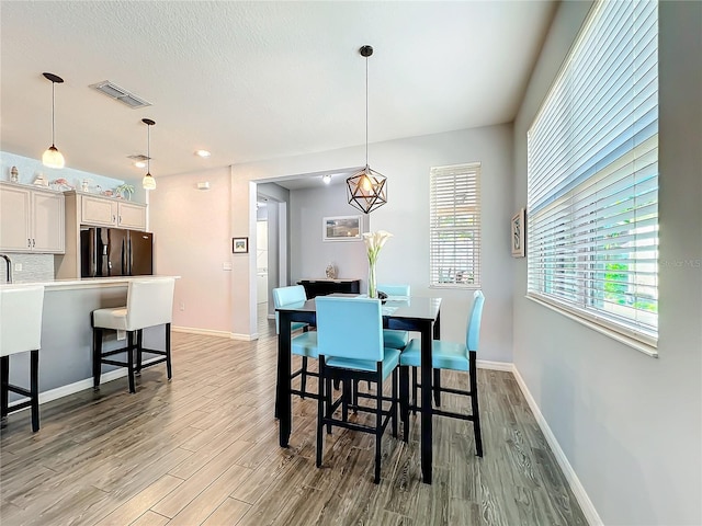 8858 Tuscany Isles Dr, Punta Gorda, FL 33950 - dining area featuring sink, light hardwood / wood-style floors, and a textured ceiling