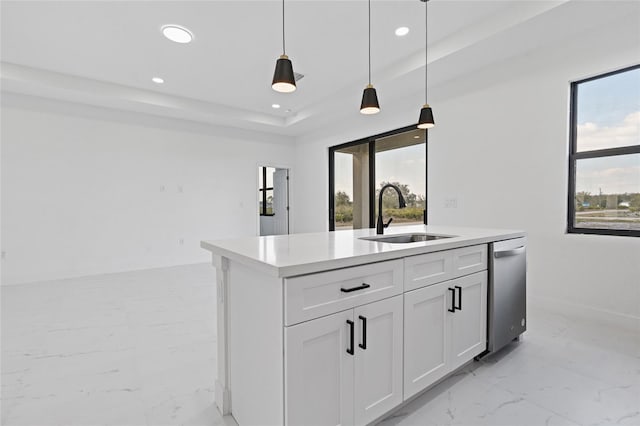 kitchen featuring sink, white cabinetry, a center island with sink, a raised ceiling, and pendant lighting