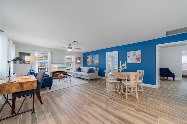 living room with ceiling fan and light wood-type flooring