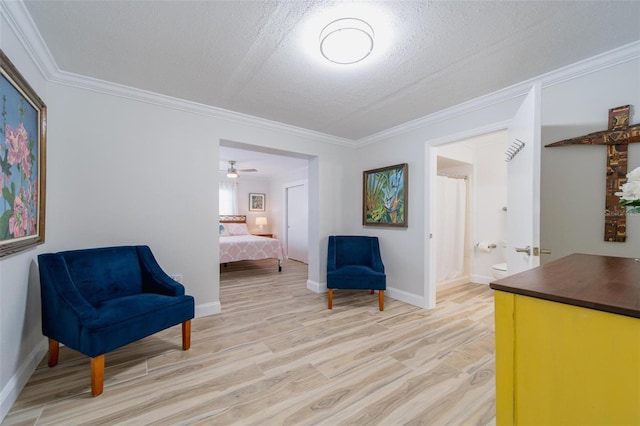 sitting room featuring a textured ceiling, crown molding, and light hardwood / wood-style flooring