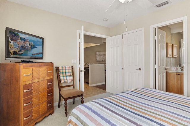 carpeted bedroom with ceiling fan and ensuite bath