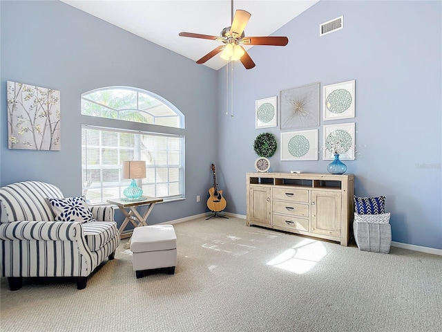 living area featuring ceiling fan, high vaulted ceiling, and light carpet