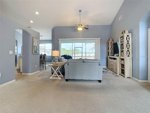 carpeted living room featuring vaulted ceiling and ceiling fan