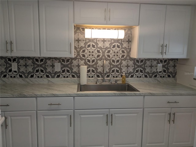 710 Aqui Esta Dr, Punta Gorda, FL 33950 - kitchen featuring white cabinetry, light stone countertops, sink, and backsplash