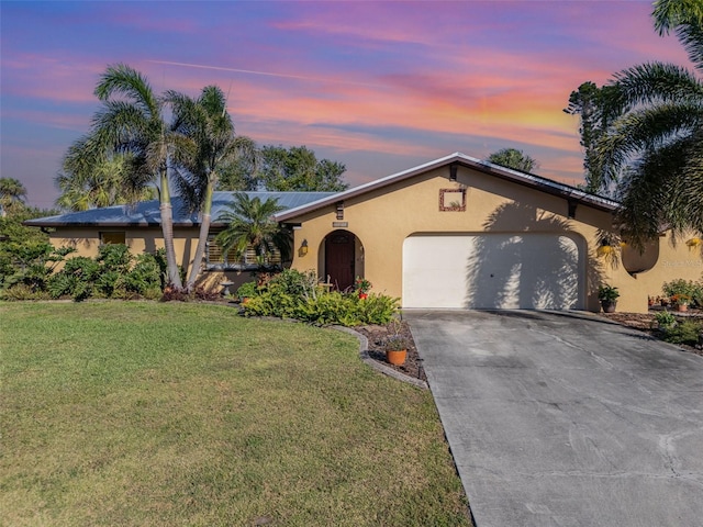 ranch-style home with a garage and a lawn