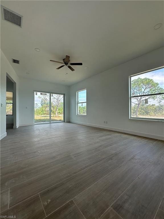 empty room featuring dark wood-type flooring and ceiling fan