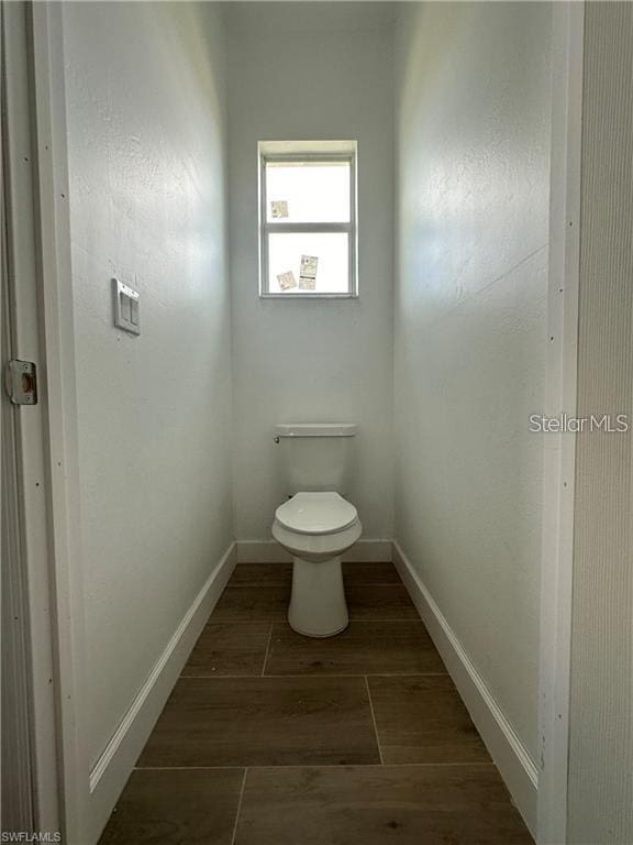 bathroom with hardwood / wood-style floors and toilet