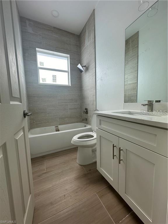 full bathroom with vanity, toilet, tiled shower / bath combo, and wood-type flooring