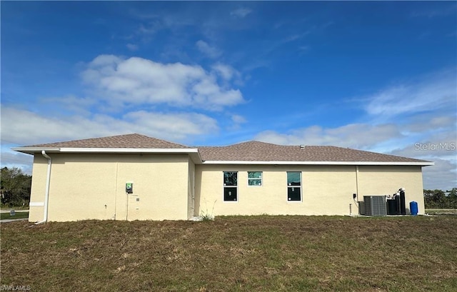 back of property with cooling unit and a yard