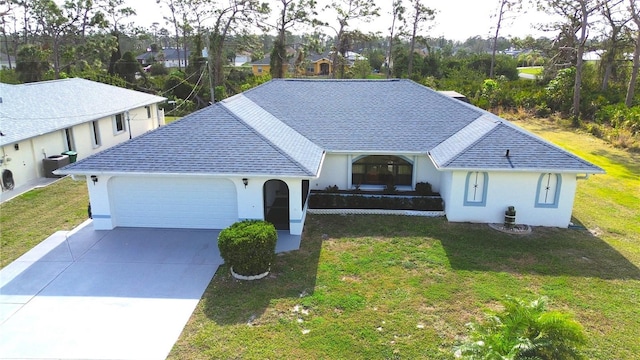 view of front of property featuring cooling unit, a garage, and a front yard