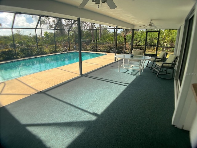 view of swimming pool featuring a patio area, ceiling fan, and glass enclosure