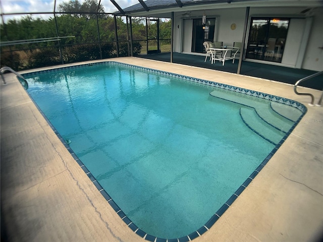 view of swimming pool featuring a lanai and a patio area