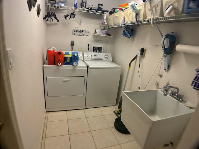 laundry area with cabinets, sink, washer and dryer, and light tile patterned floors