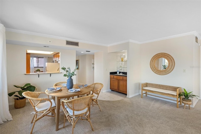 carpeted dining space featuring bar and crown molding