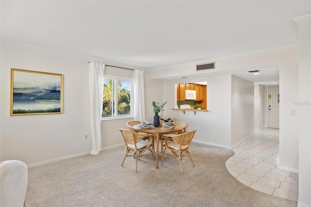 dining area with crown molding and light carpet