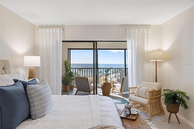 carpeted bedroom featuring a water view and access to exterior