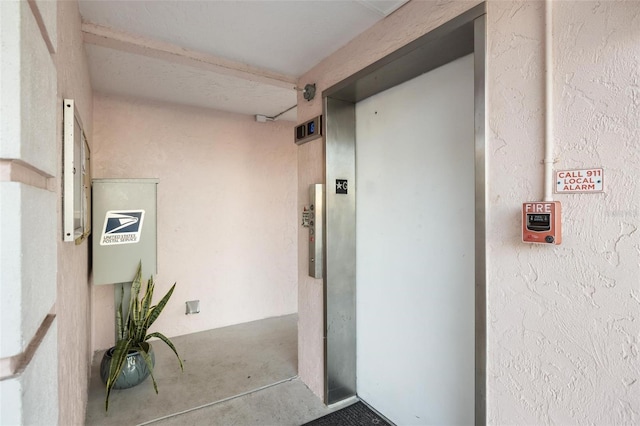 hallway featuring elevator and concrete floors