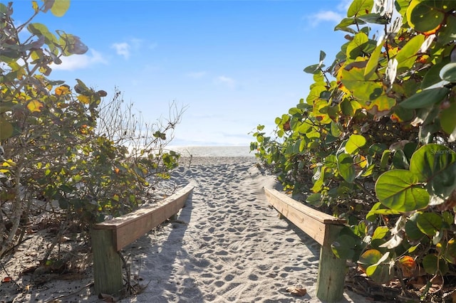 surrounding community with a water view and a view of the beach