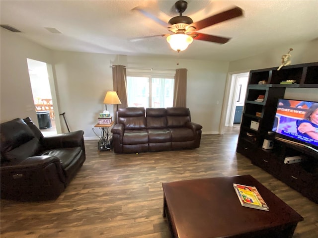 living room featuring dark wood-type flooring and ceiling fan