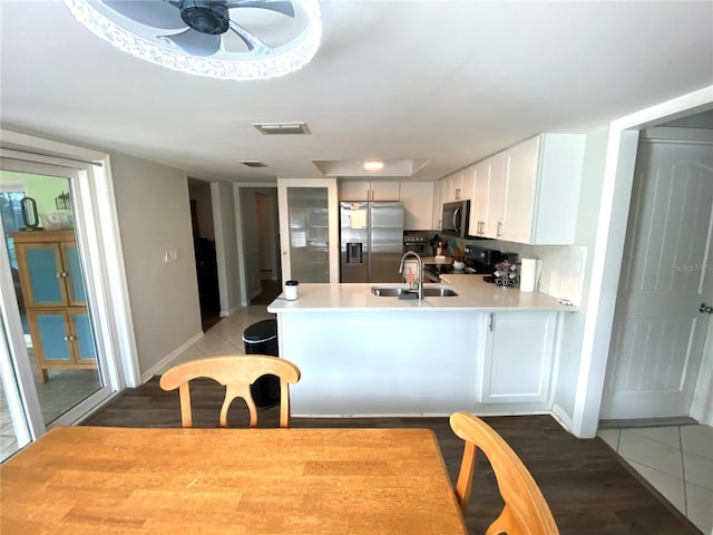 kitchen with stainless steel appliances, white cabinetry, sink, and kitchen peninsula