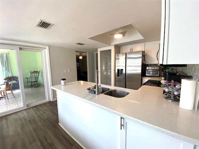 kitchen featuring stainless steel fridge with ice dispenser, kitchen peninsula, sink, and white cabinets