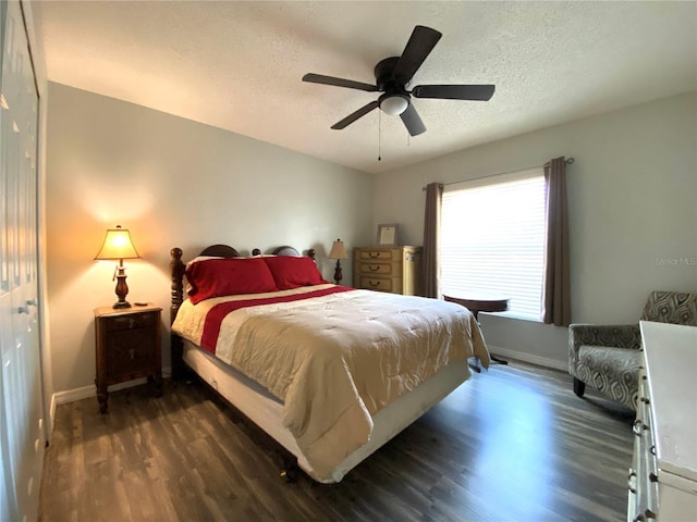bedroom with ceiling fan, dark hardwood / wood-style flooring, and a textured ceiling