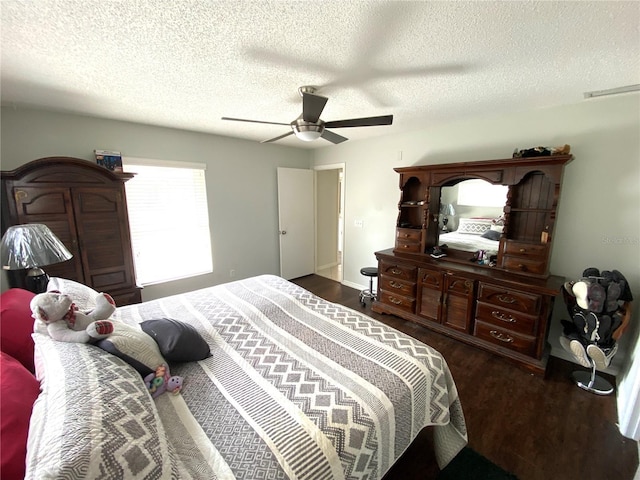 bedroom featuring dark hardwood / wood-style flooring, a textured ceiling, and ceiling fan
