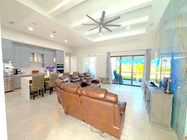 living room with beam ceiling, recessed lighting, visible vents, a high ceiling, and a ceiling fan