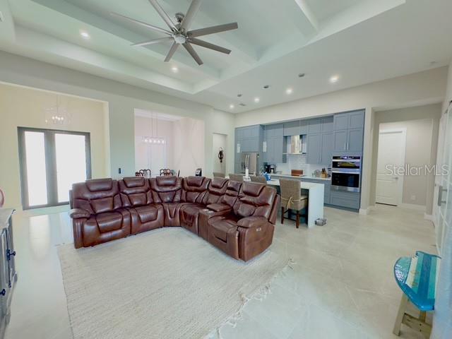 living room featuring beam ceiling, recessed lighting, a towering ceiling, ceiling fan, and coffered ceiling