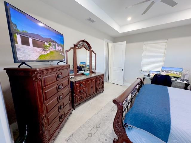 bedroom with visible vents, a raised ceiling, and recessed lighting