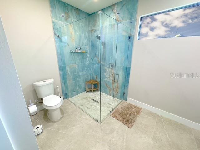 full bathroom with toilet, a stall shower, tile patterned flooring, and baseboards