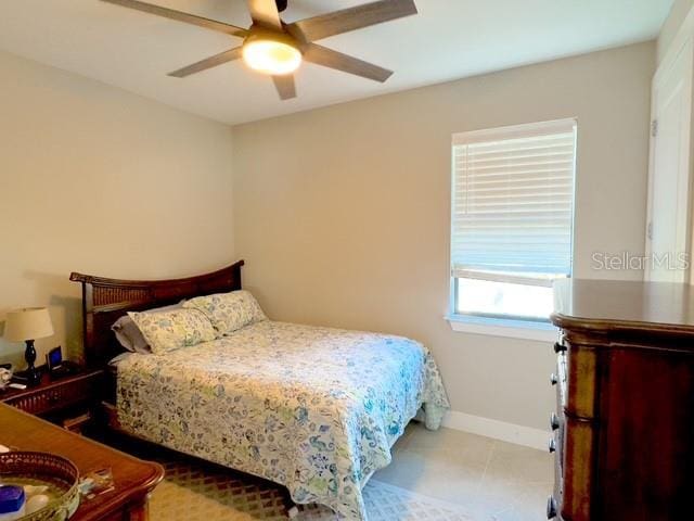 bedroom featuring ceiling fan, baseboards, and tile patterned floors