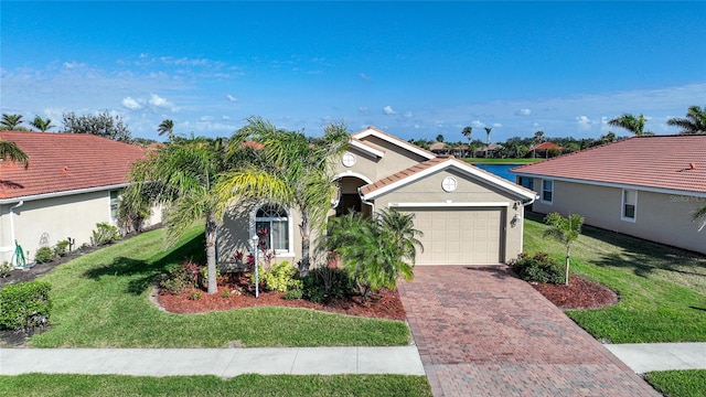 view of front facade with a garage, a front yard, and a water view