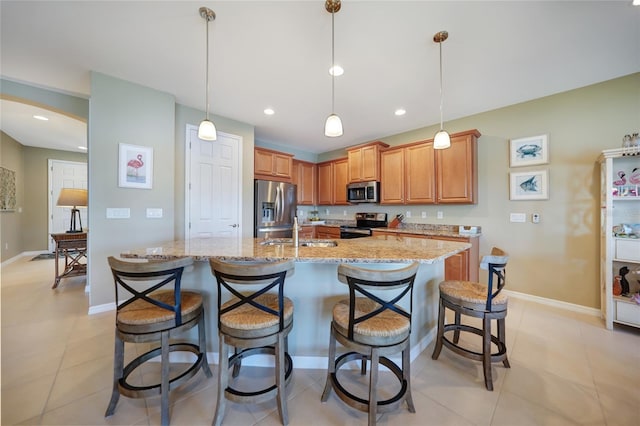 kitchen with stainless steel appliances, decorative light fixtures, a kitchen breakfast bar, and sink