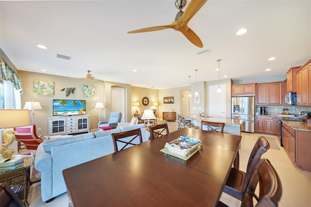 tiled dining space with ceiling fan