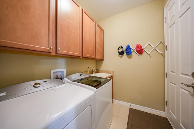 laundry room featuring cabinets, light tile patterned flooring, sink, and washer and clothes dryer