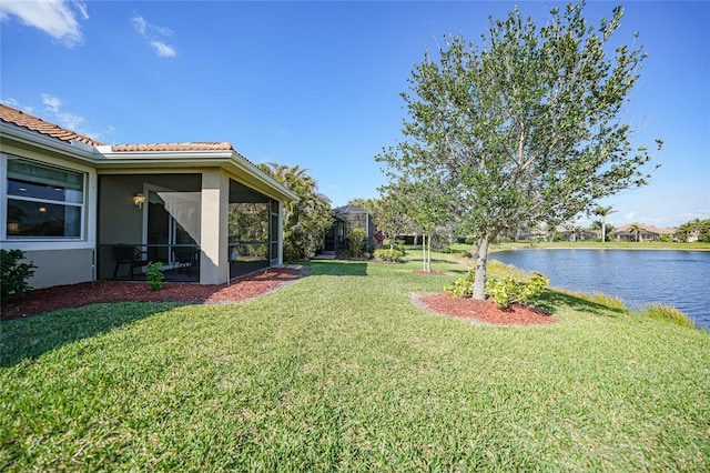 view of yard featuring a water view and a sunroom