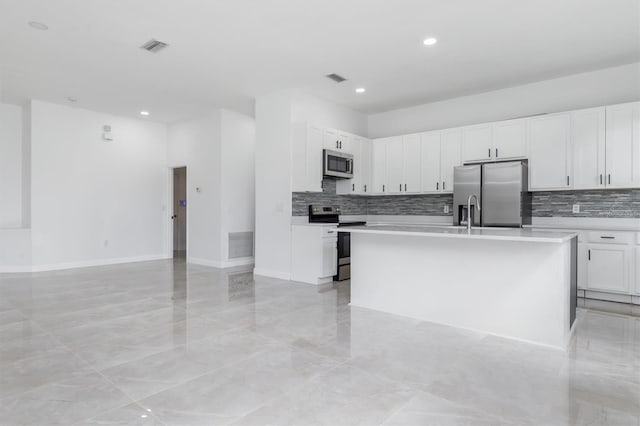 kitchen featuring an island with sink, appliances with stainless steel finishes, and white cabinets