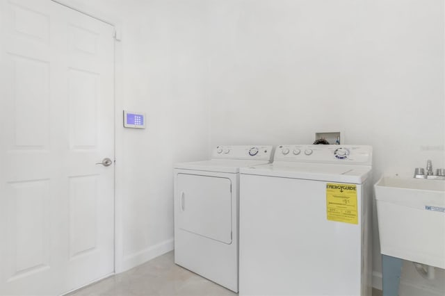 clothes washing area featuring sink and washer and dryer