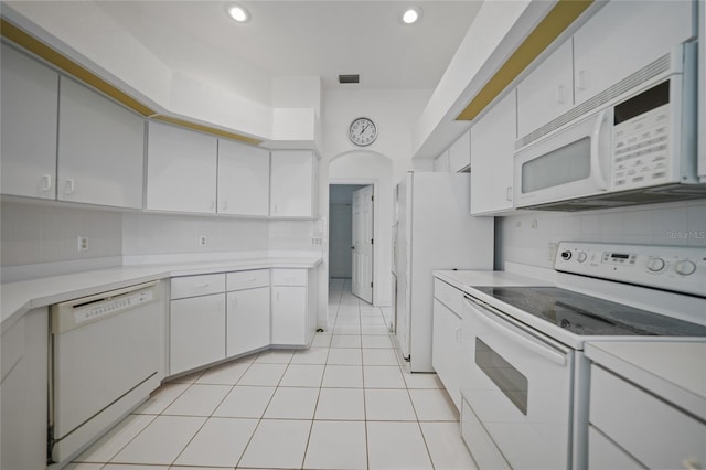 kitchen with light tile patterned floors, white appliances, decorative backsplash, and white cabinets