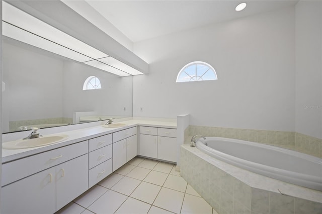 bathroom featuring vanity, tiled tub, a wealth of natural light, and tile patterned floors