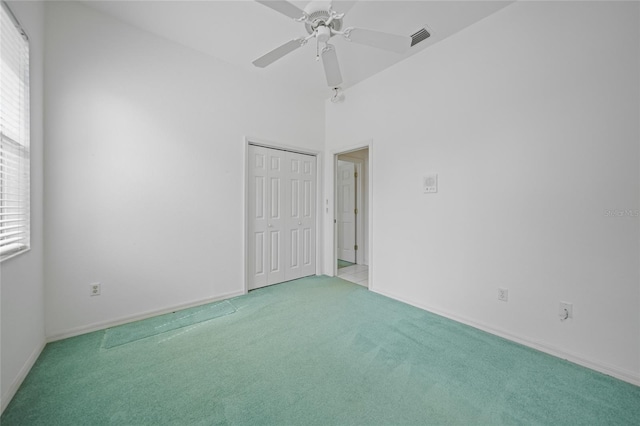 unfurnished bedroom with ceiling fan, light colored carpet, and a closet