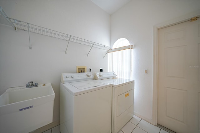 laundry area with separate washer and dryer, sink, and light tile patterned floors