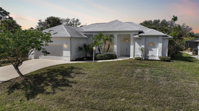 view of front facade with a garage and a lawn